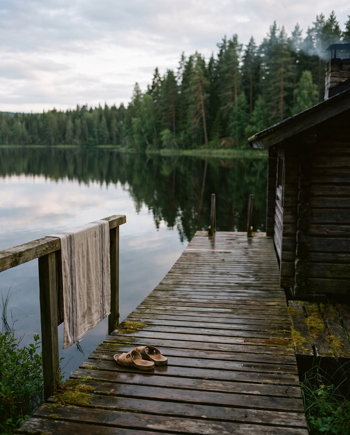 Steiger aan een meer bij een houten sauna